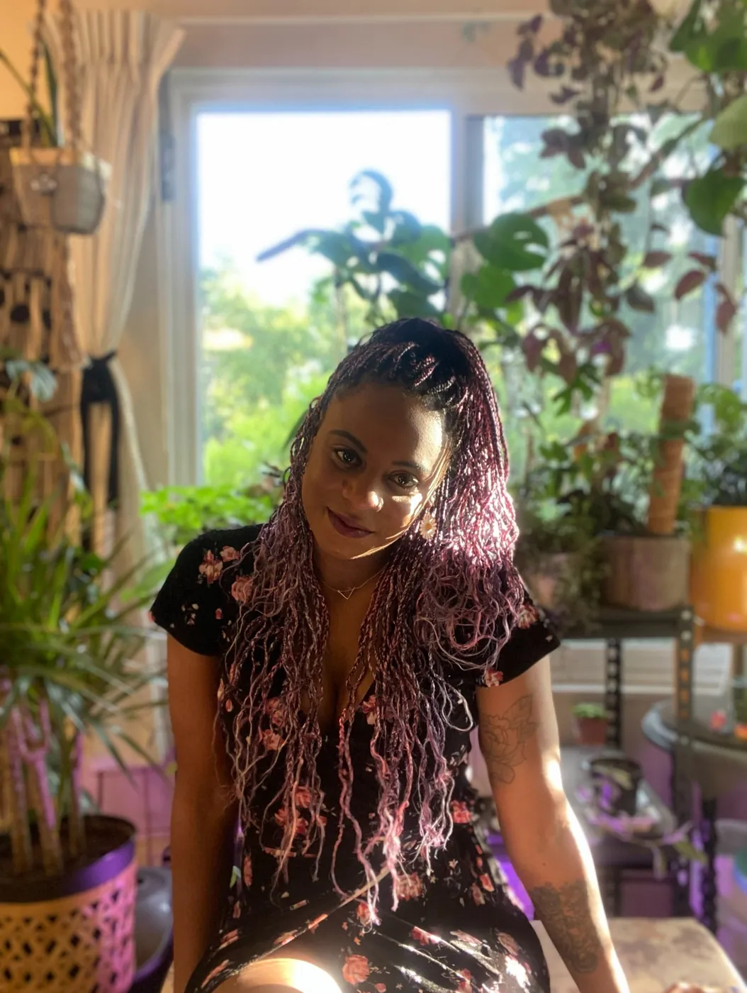 paula at home, sitting in a room full of plants