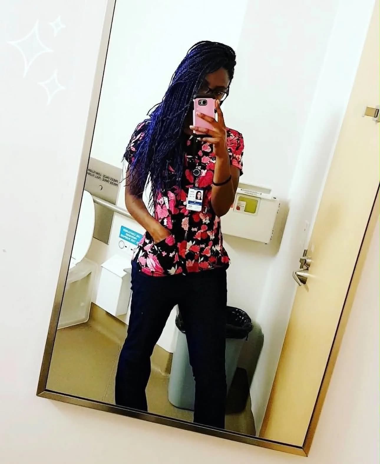 Paula in floral scrubs, a mirror selfie from her nursing days